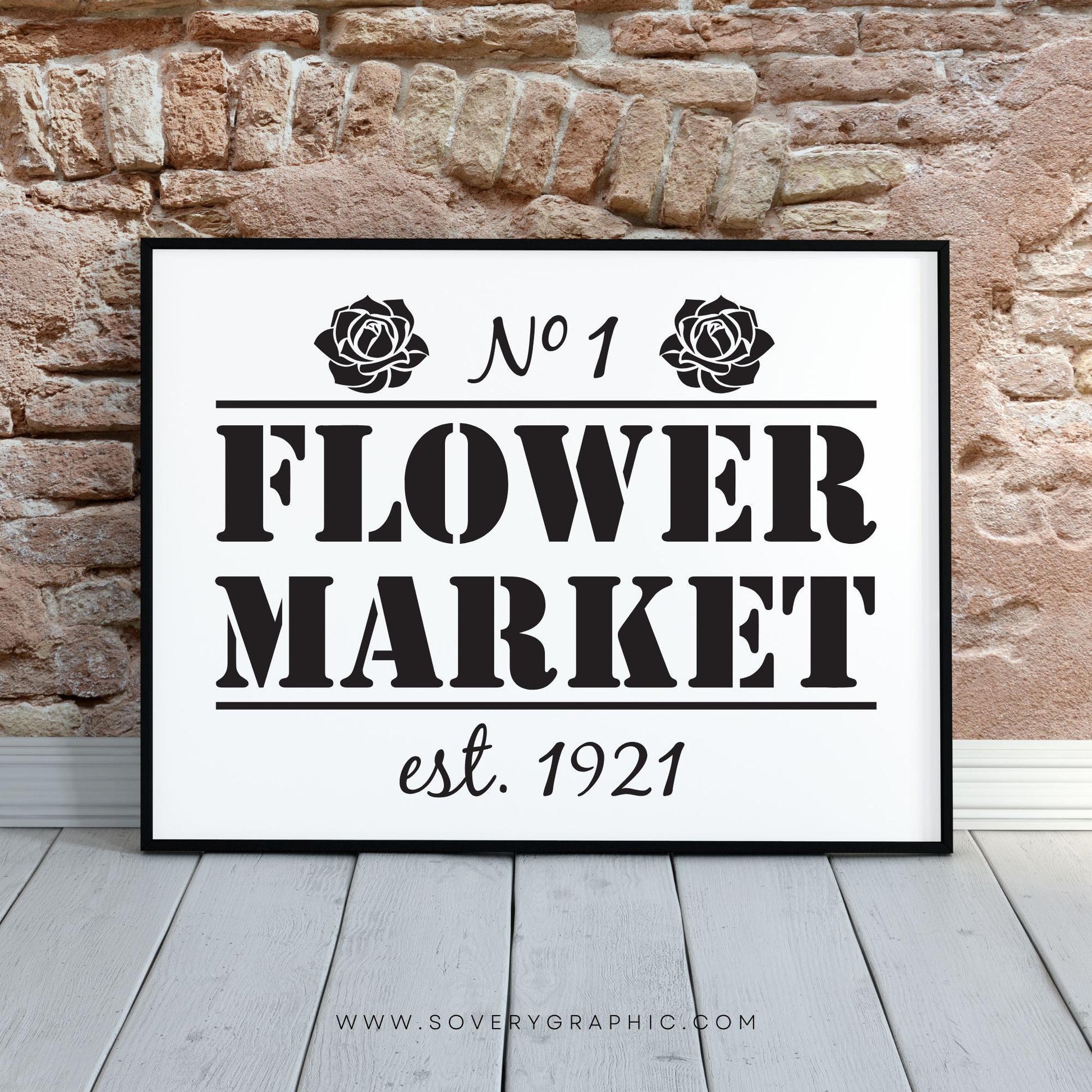 Flower Market Sign in a black frame sitting on the hardwood floors with an exposed stone wall behind the frame