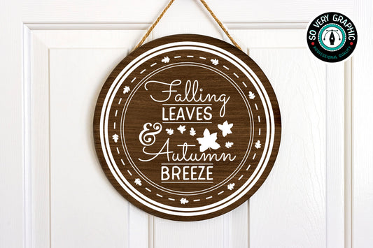 Falling Leaves & Autumn Breeze SVG Cut File in white vinyl on a dark wood round sign hanging on an interior door