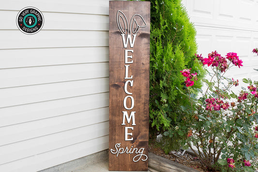 Welcome Spring Vertical Porch Sign SVG design on a dark wood panel on the front porch