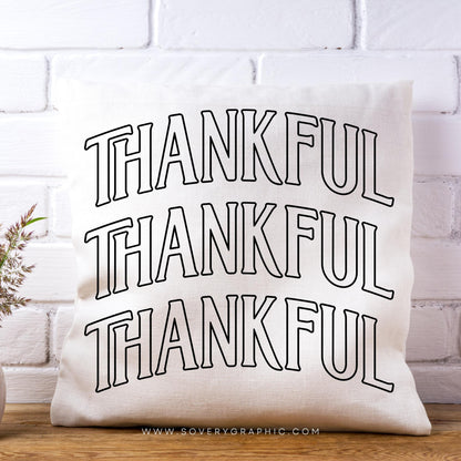 White pillow with 'THANKFUL' text on a white brick wall background